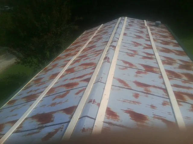Rusted metal roof panels with new wood purlins before replacement — Storm Damage Roof Repair in Orlando by Roofing Brothers